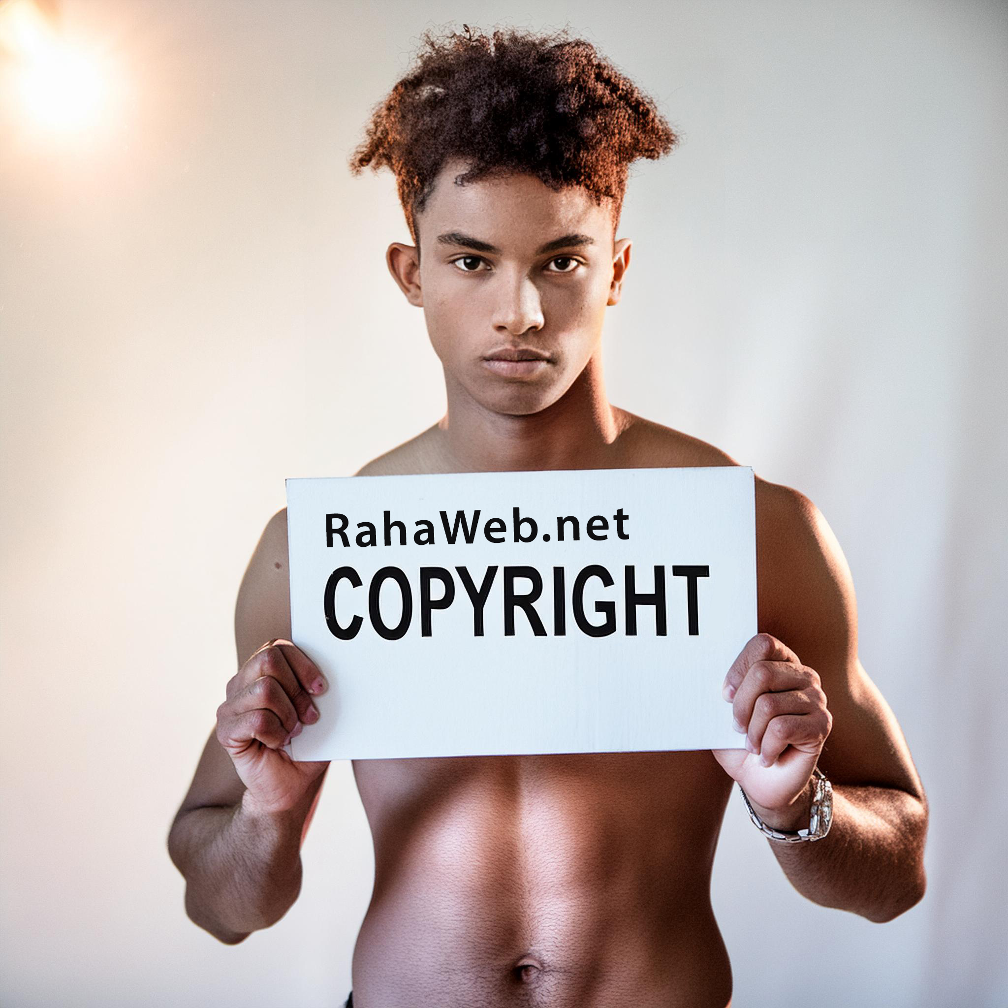 A young bicultural man holds a signs that says RahaWeb.net Copyright