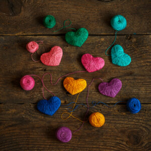 Multicolored Hearts with a balls of thread on old shabby wooden background. Image of Valentines day - Represents Token of Love and Attraction article on RahaWeb