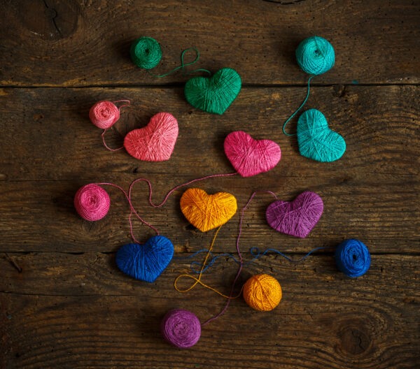 Multicolored Hearts with a balls of thread on old shabby wooden background. Image of Valentines day - Represents Token of Love and Attraction article on RahaWeb