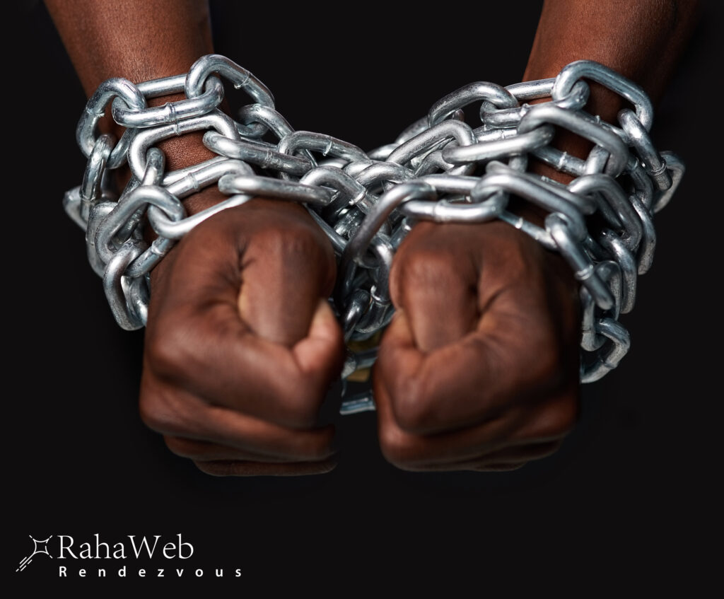 A man's hands tied up with chains against a black background - represents Juneteenth on RahaWeb